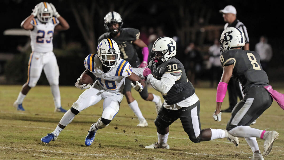 Sumter’s Anthony Dinkins-McCall tries to elude Blythewood defenders Bryan Crosby (30) and Chad Ishmael (8).