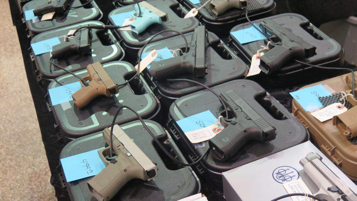 In this file photo, an array of handguns are on display at a gun show.