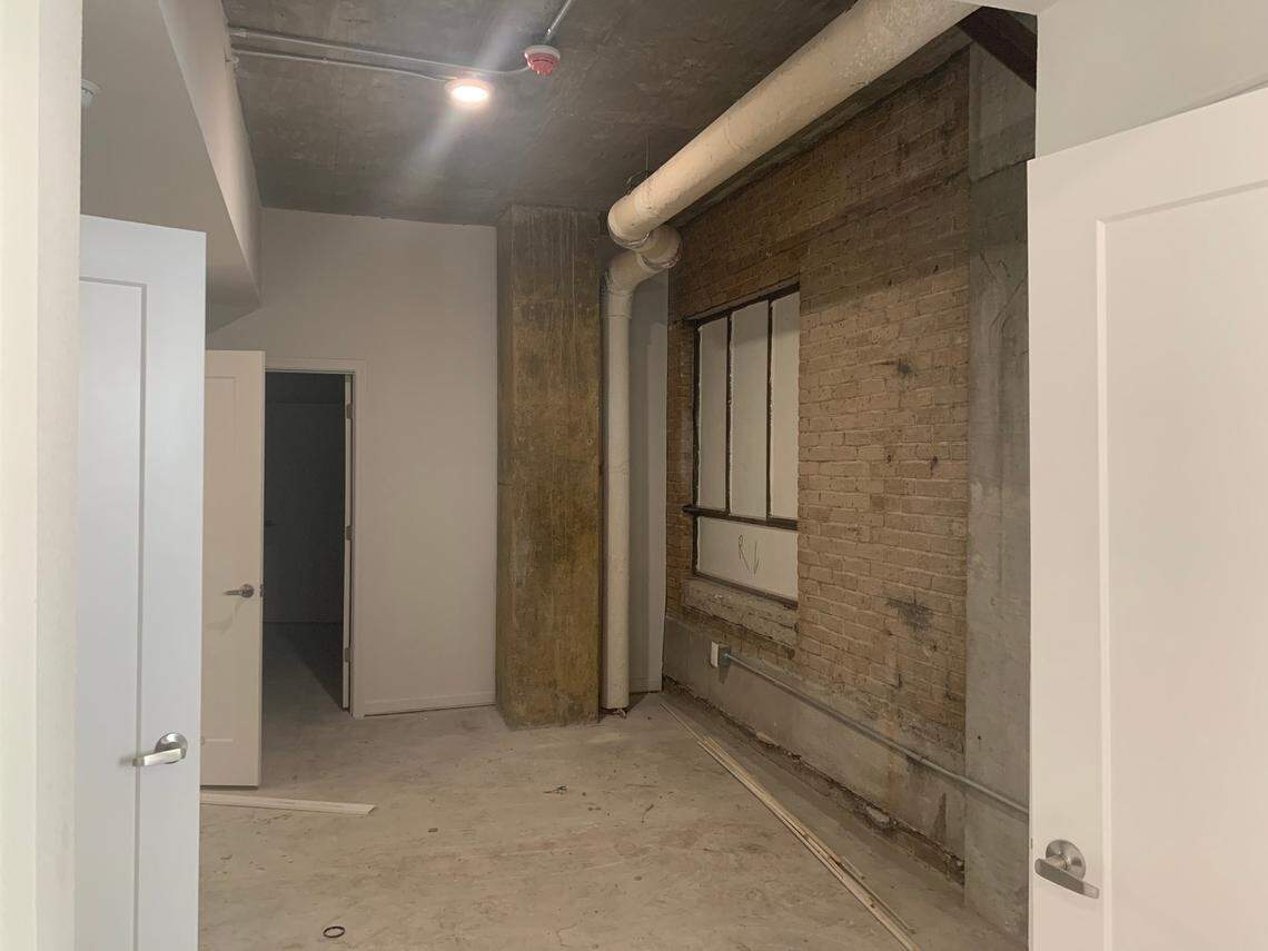 One unit of The Lady apartments in the Main Street district of Columbia has an exposed brick wall and window in the hallway. Developers discovered the wall of a connecting building behind layers of plaster and drywall in the unit and decided to keep it exposed.