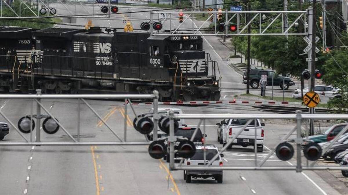 Cars wait at the railroad crossing at Whaley and Assembly streets.