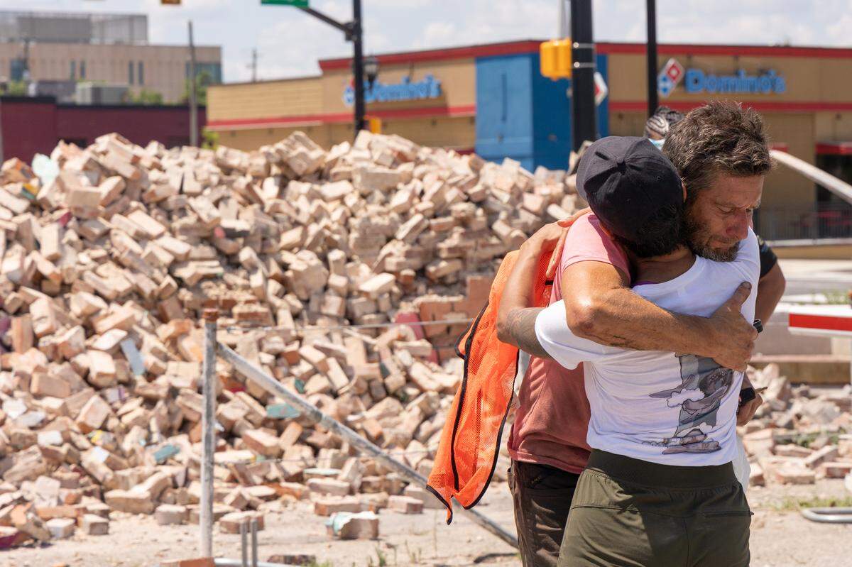 Muralist Lauren Andreu embrases Alan Todd after he knocked down her mural on the side of the Hunter-Gartherer location on South Main Street in Columbia, South Carolina Saturday, June 28, 2025. Volunteers will try and gather the painted bricks to possibly reconstruct the mural.