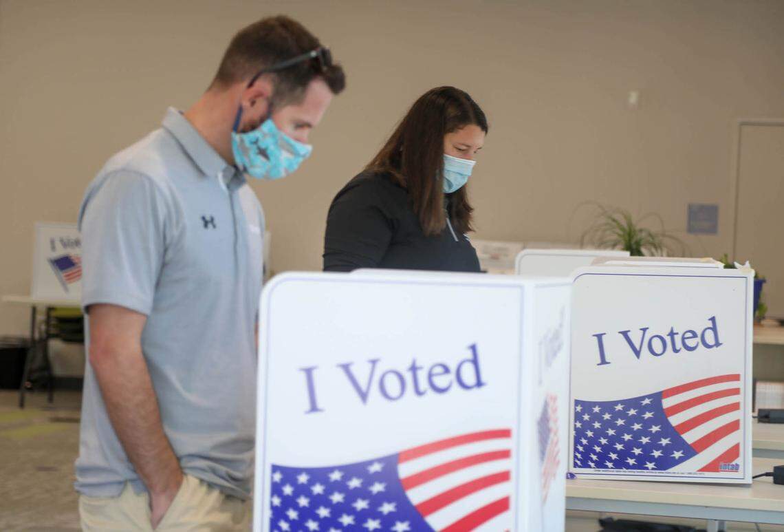 Scott Miller and Sarah Corbett cast their ballots at the Ward 13 precinct at Rosewood Elementary School on Tuesday, Nov. 2, 2021.