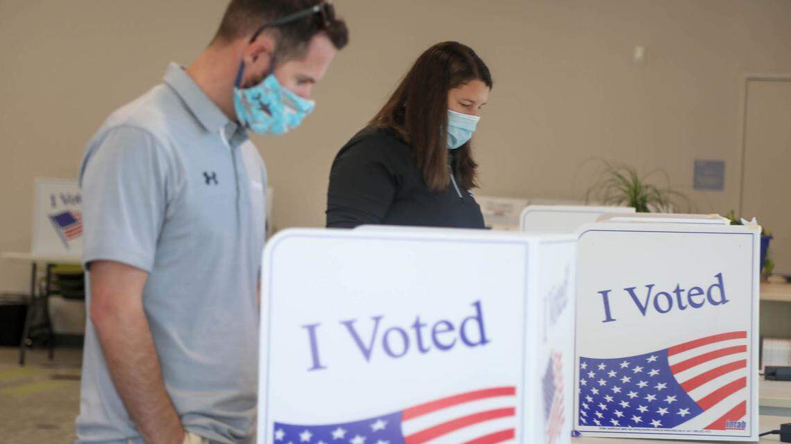 Scott Miller and Sarah Corbett cast their ballots at the Ward 13 precinct at Rosewood Elementary School on Tuesday, Nov. 2, 2021.