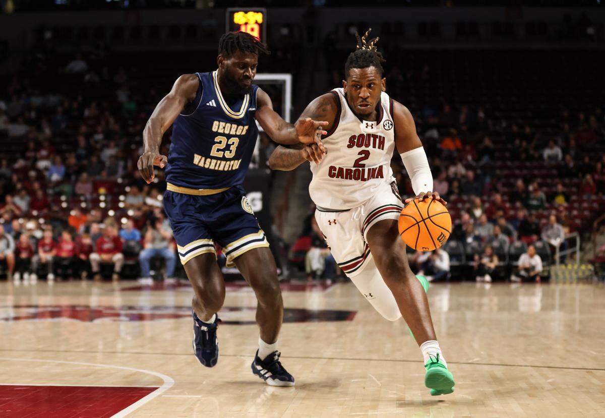 South Carolina forward B.J. Mack (2) drives past George Washington center Babatunde Akingbola (23) during the first half of the Gamecocks’ game at Colonial Life Arena in Columbia on Friday, December 1, 2023.