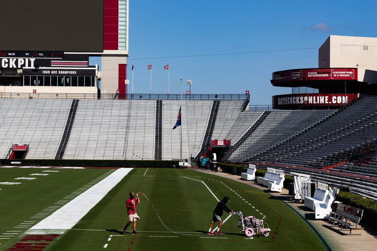 Workers at the University of South Carolina paint the field at Williams-Brice Stadium on Friday, September 12, 2025.