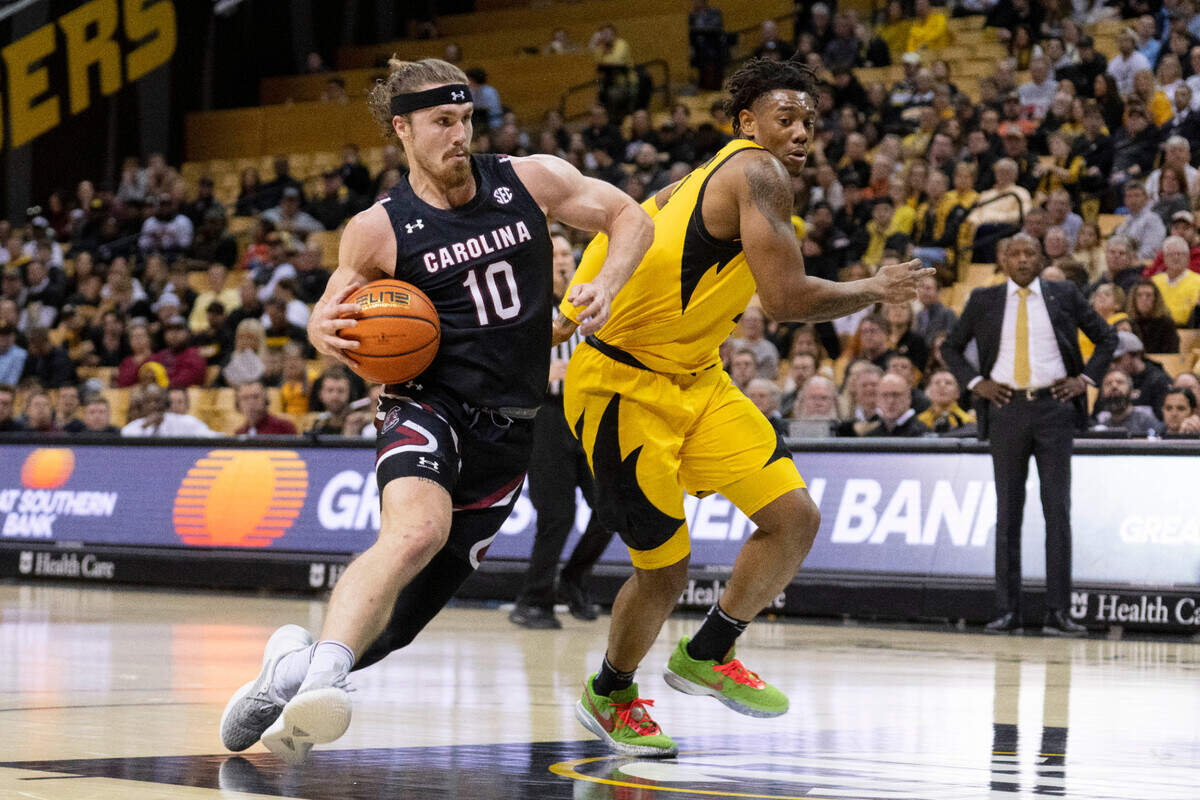 South Carolina’s Hayden Brown, left, dribbles around Missouri’s DeAndre Gholston, right, during the first half of an NCAA college basketball game Tuesday, Feb. 7, 2023, in Columbia, Mo. (AP Photo/L.G. Patterson)