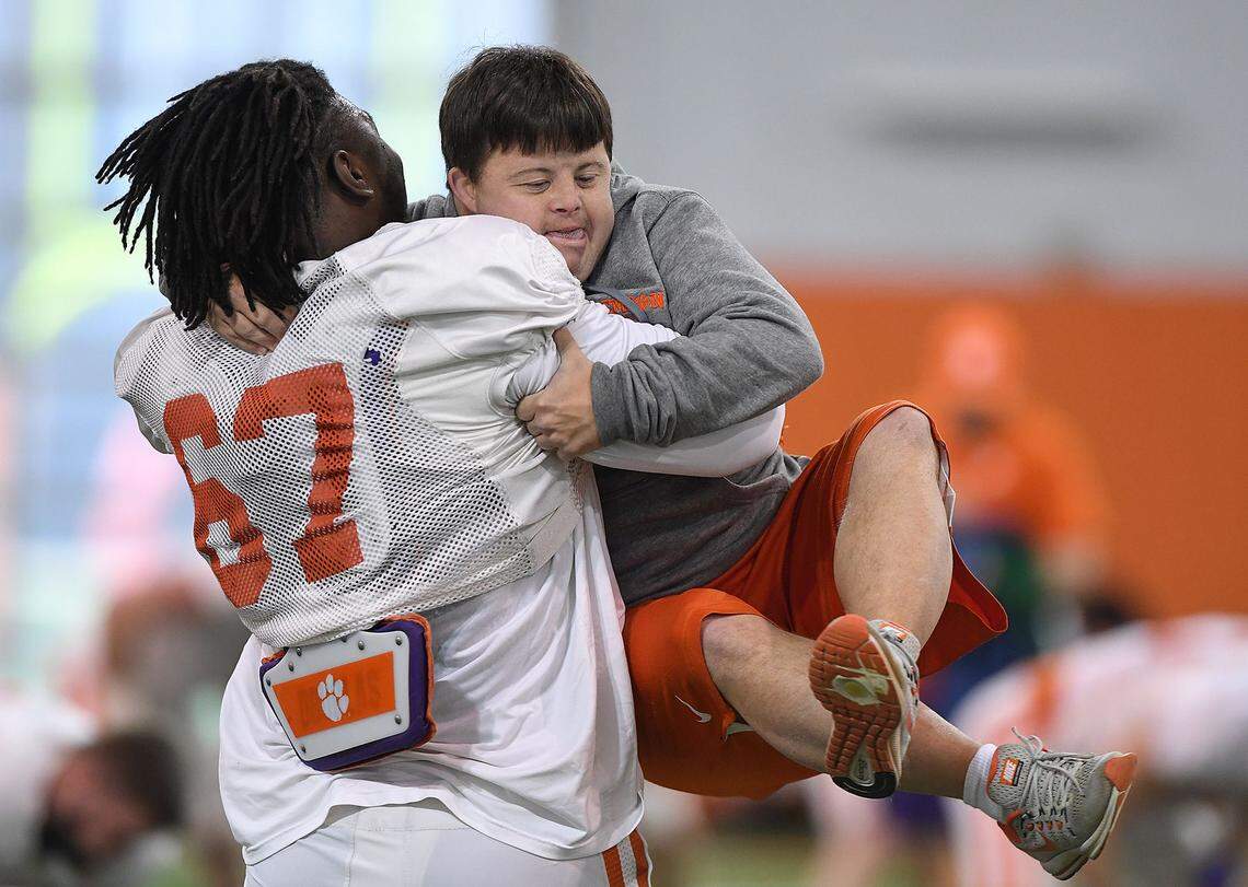 Clemson defensive lineman Albert Huggins (67) hugs equipment manager David Saville during the Tigers Cotton Bowl practice on Friday, December 14, 2018.