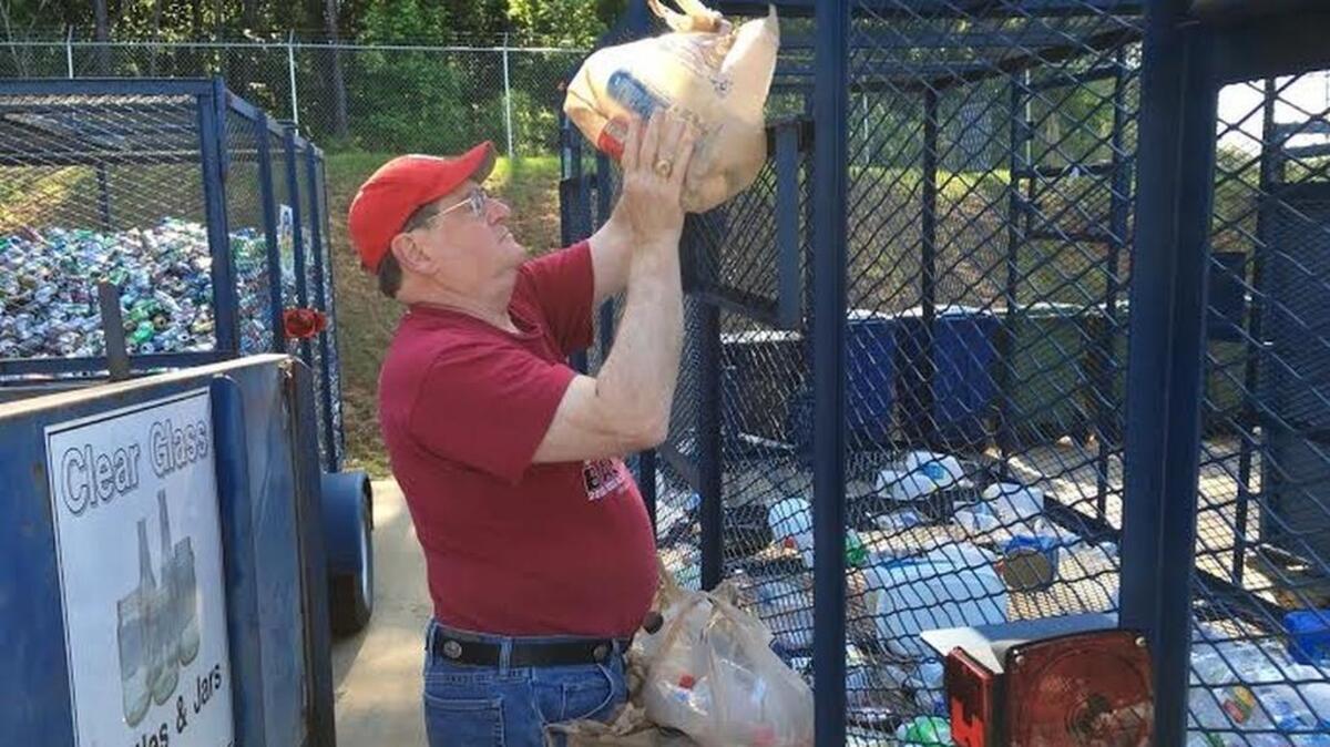 Leonard Cone empties plastic bottles for recycling at the trash disposal center near Irmo.