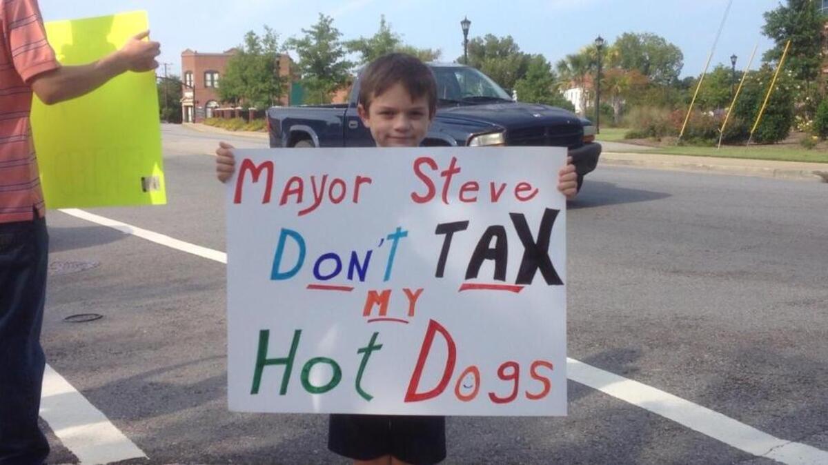 
Alexander Howard, 9, joined his father, Wes, and other foes of a proposed meal tax rallying outside Lexington Town Hall on Monday.
