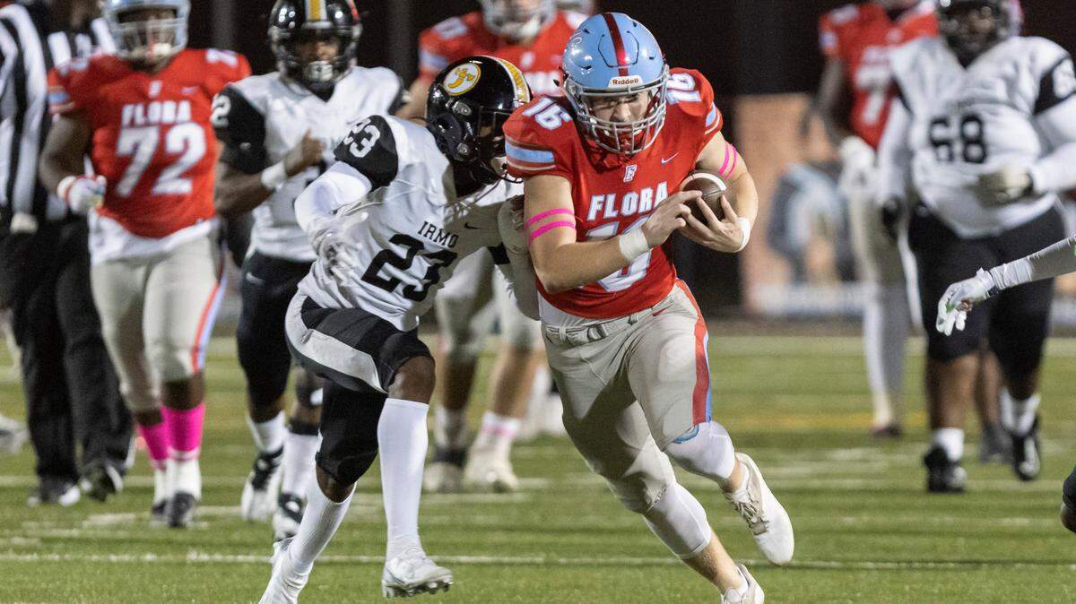 Colby Ridgell (16) of AC Flora carries the ball while fending off the tackle of Matthew Blocker (23) of Irmo at Memorial Stadium on Oct. 14, 2022.