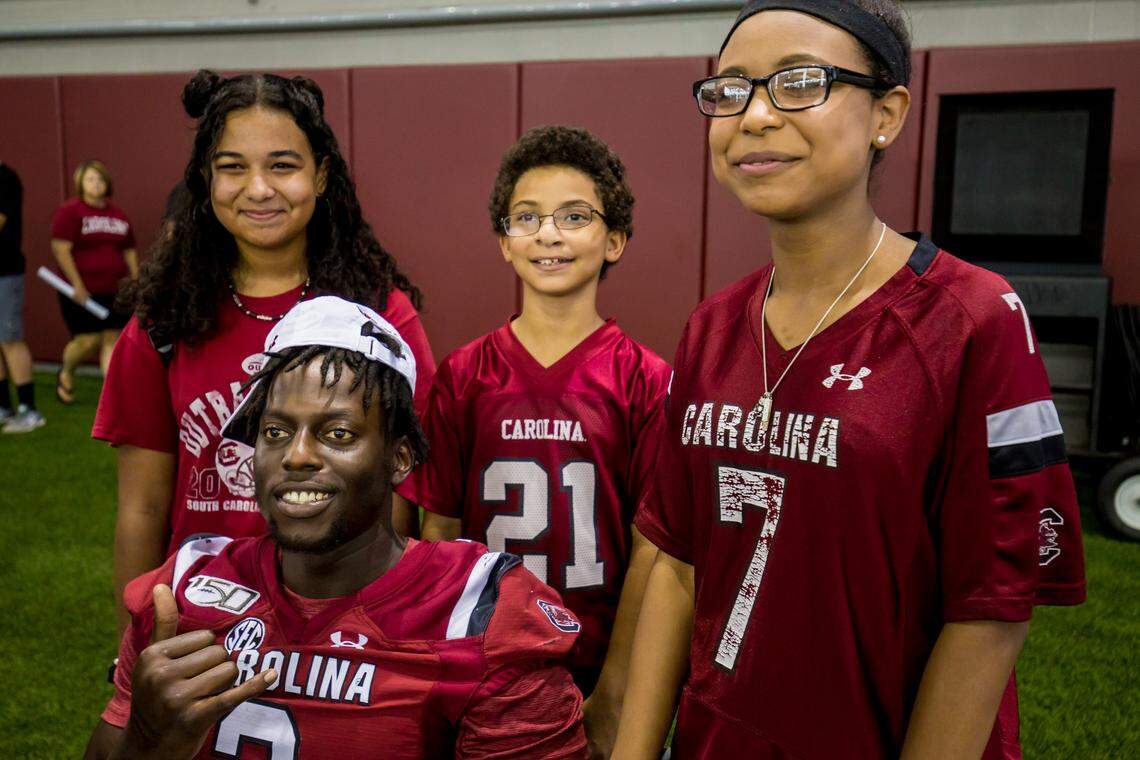 From left, Fayth Mitchell, RJ Mitchell, Jr., and Sabrina Mitchell pose with defensive lineman Javon Kinlaw during USC Fan Day ahead of the 2019 season at the Gamecocks football practice facility.