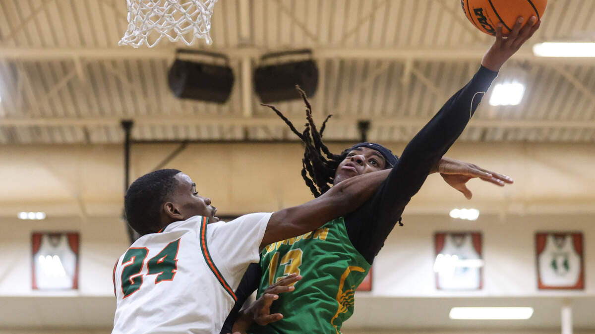 Milton McCray (13) of C.A. Johnson puts up a shot over Jayden Heyward (24) of Eau Claire during the MLK Bash at Eau Claire High School in Columbia on Monday, January 20, 2025.