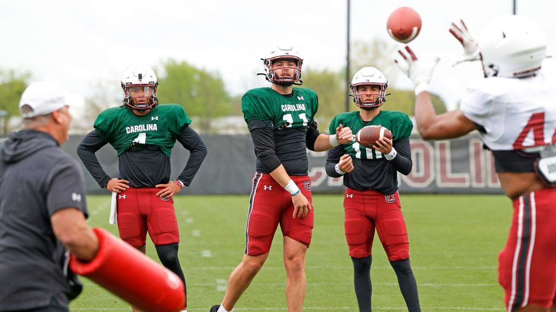 South Carolina’s quarterbacks work out at Thursday’s practice. Robby Ashford, left, and Dante Reno, right, look on as Davis Beville throws a pass.