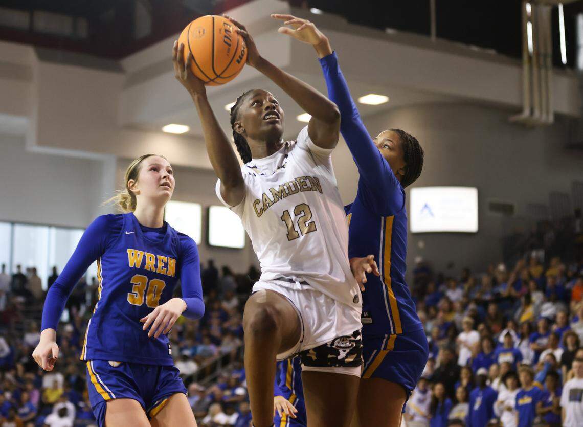 Joyce Edwards (12) of Camden goes up for a shot over Raina McGowens (5) of Wren as teammate Riley Stack (30) looks on during Camden’s game against Wren in the SCHSL Class 3A State Championship at the USC Aiken Convocation Center on Friday, March 3, 2023.