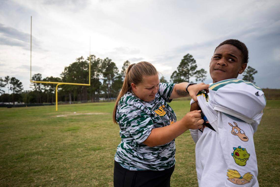 Coach Maranda McCaskill fixes the pads of Khalil Sutton during practice at North Central High School in Kershaw on Monday, October 4, 2021.