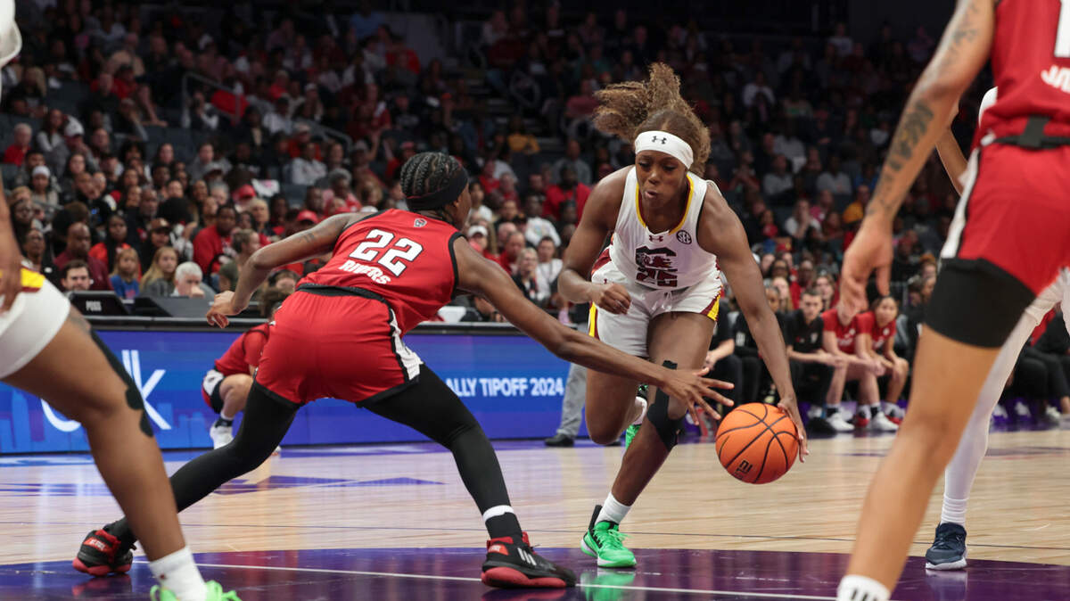 University of South Carolina guard Raven Johnson (25) drives past NC State guard Saniya Rivers (22) during the second half of action in the Ally Tipoff at the Spectrum Center in Charlotte Sunday. No. 1 South Carolina won, 71-57, for its 40th consecutive victory.