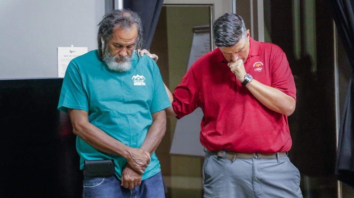 James Sanders, left, who is know widely as Uncle James, and Ryan Paolucci, the leader of The Huddle, a men’s group at Village Church, pray together after the two met at a meeting at the church. The group funded and facilitated the repair of a van used by Sanders and others in North Pointe Estates.