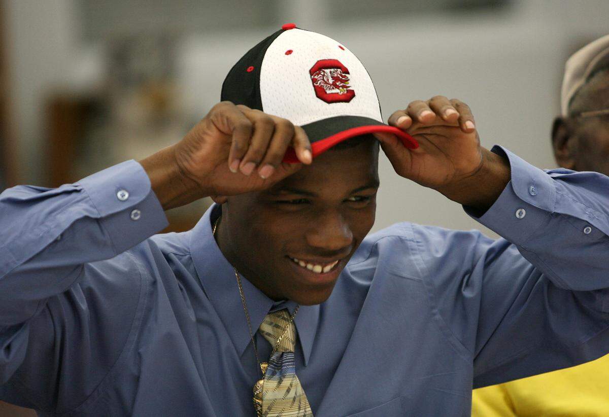From: Palmetto High School’s Joe Hills tries on a South Carolina cap after signing a letter of intent with the Gamecocks