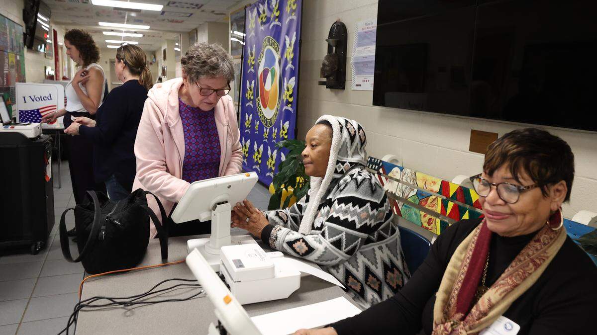 Poll manager Trish Wimberly helps Becky Sutusky register to receive her ballot in the municipal election at Hand Middle School on Tuesday, Nov. 4, 2025.