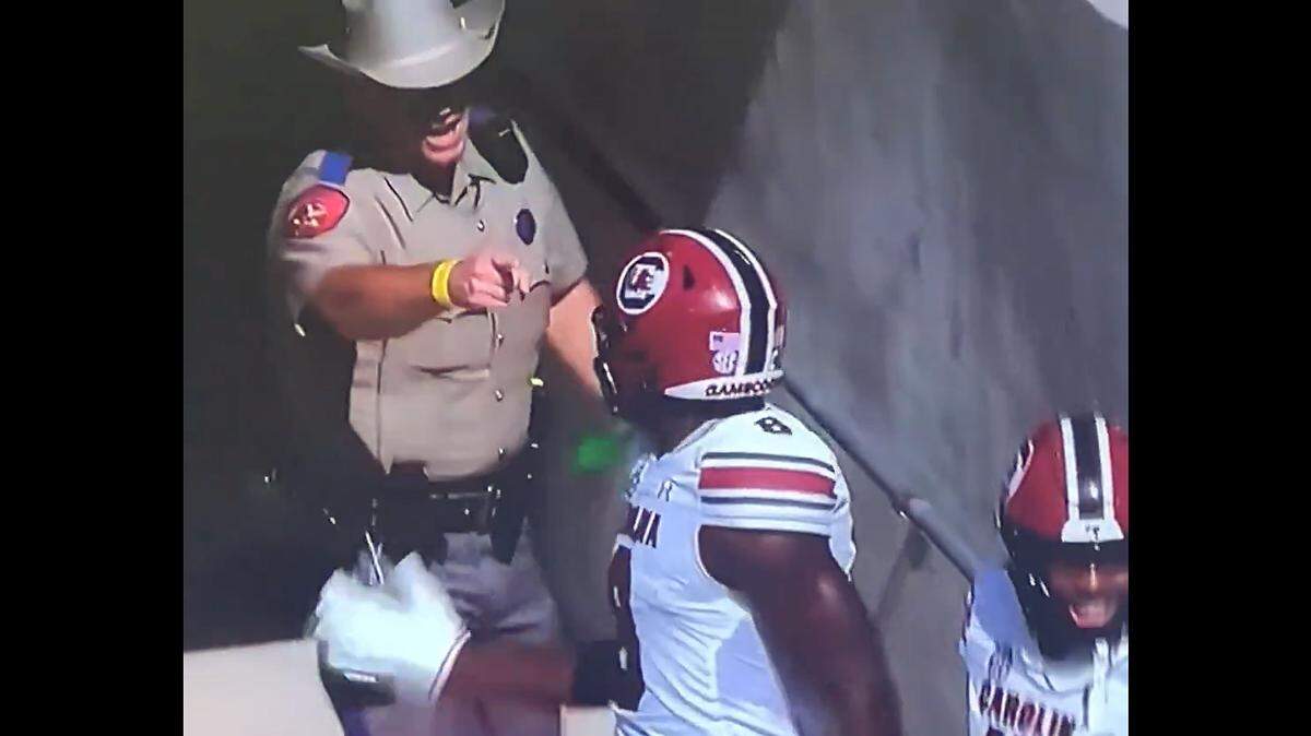 Texas Highway Patrol senior trooper Matthew Sliva (top) was ‘relieved of his gameday duties’ and was the subject of an administrative investigation after his interaction with South Carolina receiver Nyck Harbor (No. 8) and other players in November went viral.