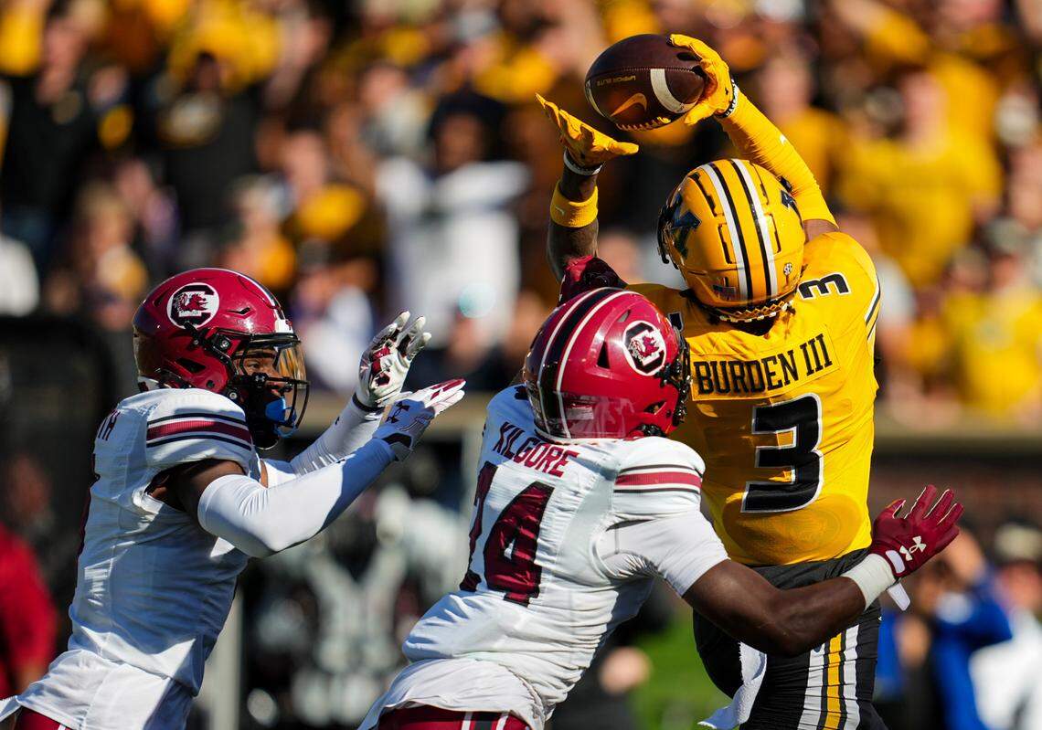 Missouri Tigers wide receiver Luther Burden III (3) catches a touchdown pass against South Carolina Gamecocks defensive back Jalon Kilgore (24) and defensive back DQ Smith (1) during the first half at Faurot Field at Memorial Stadium.