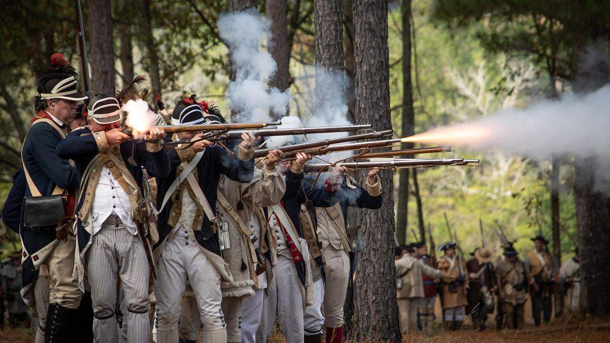 Reenactors fire muskets during a recreation of the Battle of Camden.