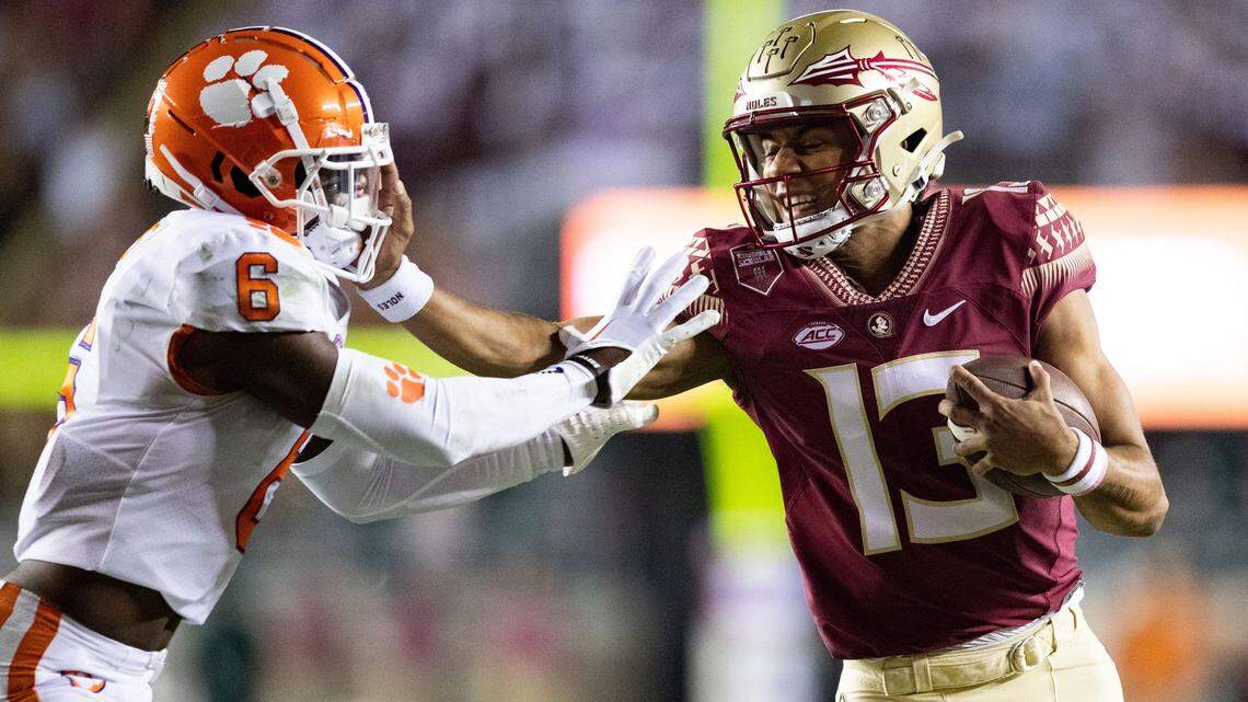Florida State Seminoles quarterback Jordan Travis (13) stiff arms Clemson Tigers cornerback Sheridan Jones (6).The Clemson Tigers defeated the Florida State Seminoles 34-28 at Doak Campbell Stadium on Saturday, Oct. 15, 2022.