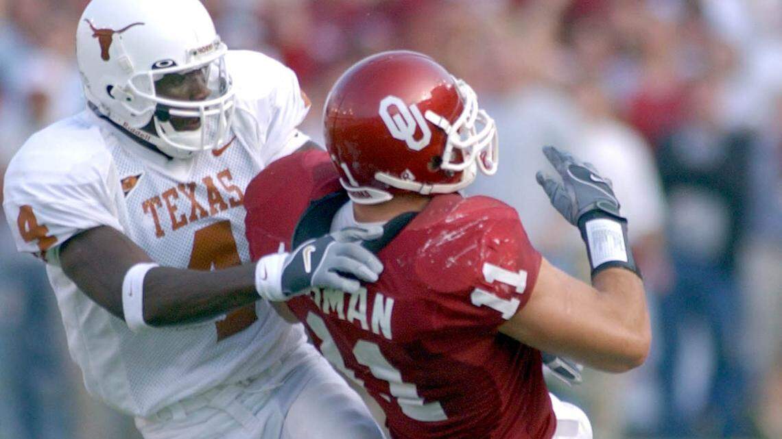 Oklahoma linebacker Teddy Lehman (11) is tackled Texas wide receiver Roy Williams (4) after an interception in the third quarter in Dallas, Saturday, Oct. 12, 2002.