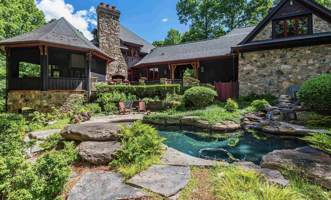 The lushly landscaped backyard includes a pool with a waterfall.