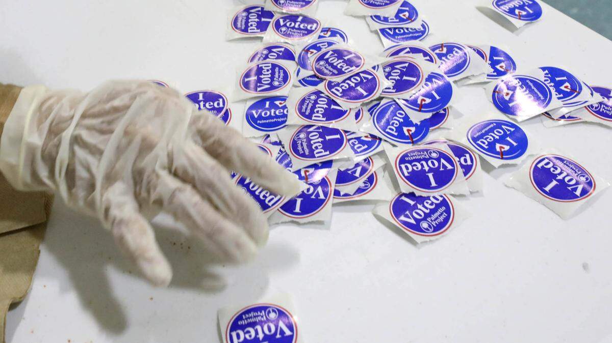 Precinct worker Carol Reardon wears gloves to sort ‘I voted stickers’ at Brennen Elementary School. Three precincts voted at the school because there were not enough precinct workers to staff all then locations. 6/9/20