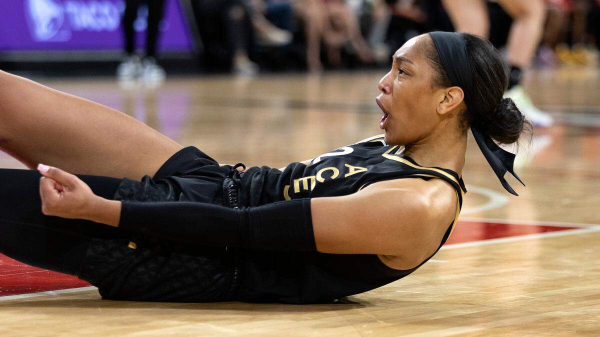 Las Vegas Aces forward A’ja Wilson (22) reacts as he falls to the court after making a basket during the first half of a WNBA basketball game against the Phoenix Mercury, Saturday, May 21, 2022, in Las Vegas. (AP Photo/Ellen Schmidt)