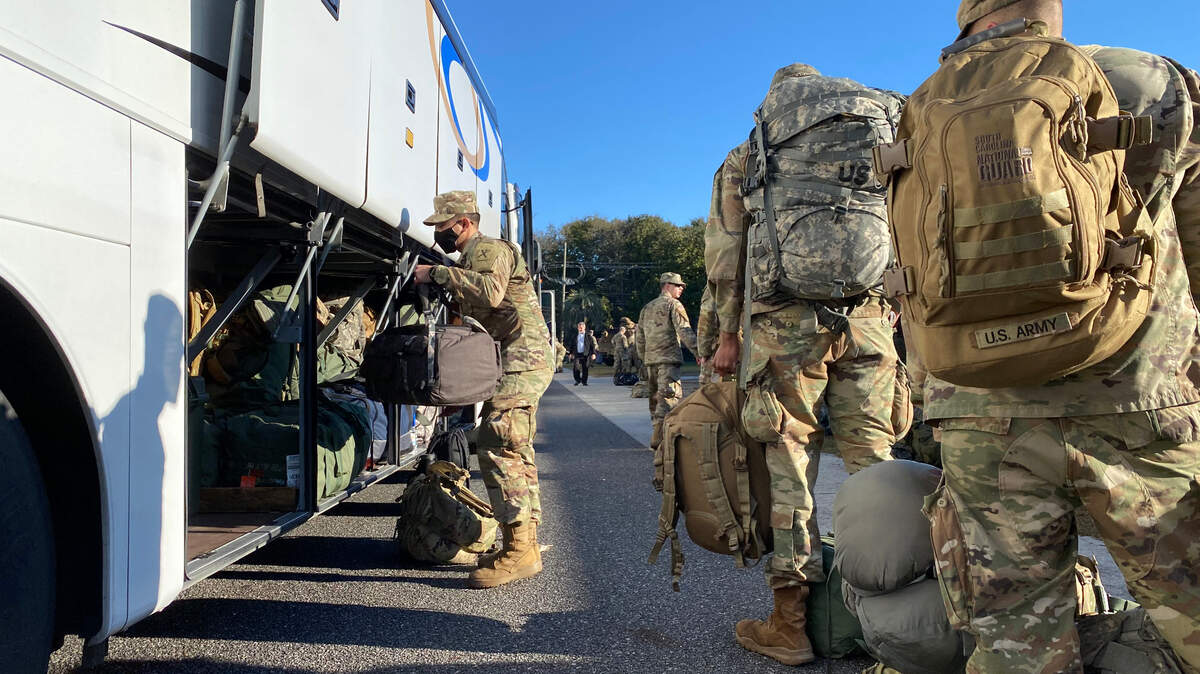 U.S. Army National Guard Soldiers with the South Carolina National Guard load buses with equipment and receive a briefing from U.S. Army Maj. Gen. Van McCarty, the adjutant general for South Carolina, at the South Carolina National Guard readiness center in Mount Pleasant, South Carolina, Jan. 14, 2021, before traveling to the District of Columbia in support of the 59th Presidential Inauguration. The South Carolina National Guard will join service members from other states and territories in the nation’s capital to provide support for the 59th Presidential Inauguration, Jan. 20, 2021, in the District of Columbia. The support of the National Guard, including South Carolina, is in support of the District of Columbia National Guard. National Guard support includes manning traffic control points, security checkpoints, and managing the flow of personnel to ensure spectators are able to move around smoothly and safely before, during, and after the inauguration events. The National Guard routinely performs these types of missions during major events and is able to seamlessly integrate with interagency partners. (U.S. Army National Guard photo by Sgt Brian Calhoun, South Carolina National Guard)