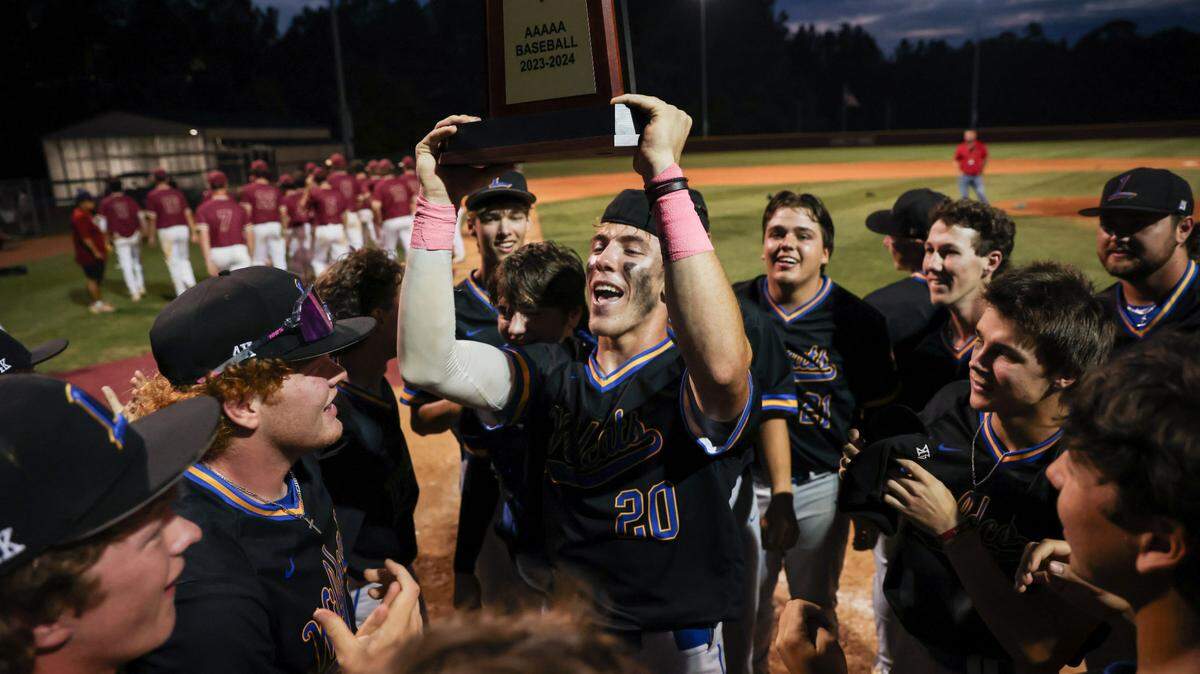 Jackson Cionek (20) of Lexington hoists the trophy in the air after defeating Ashley Ridge in the SCHSL Class 5A Baseball State Championship at Ashley Ridge High School in Summerville on Friday, May 24, 2024.