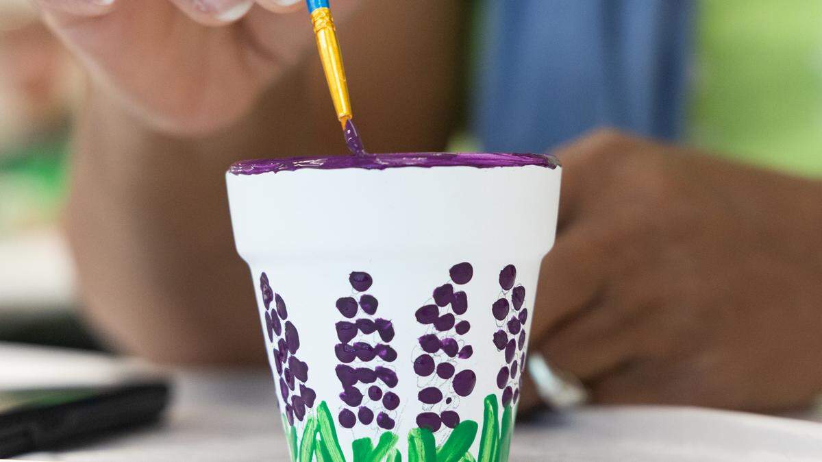 Rosalyn Merriweather paints hyacinth onto a small pot at the North Main branch of the Richland County Library on Thursday, May 22, 2025. She says that she comes to the free classes at her local library often.
