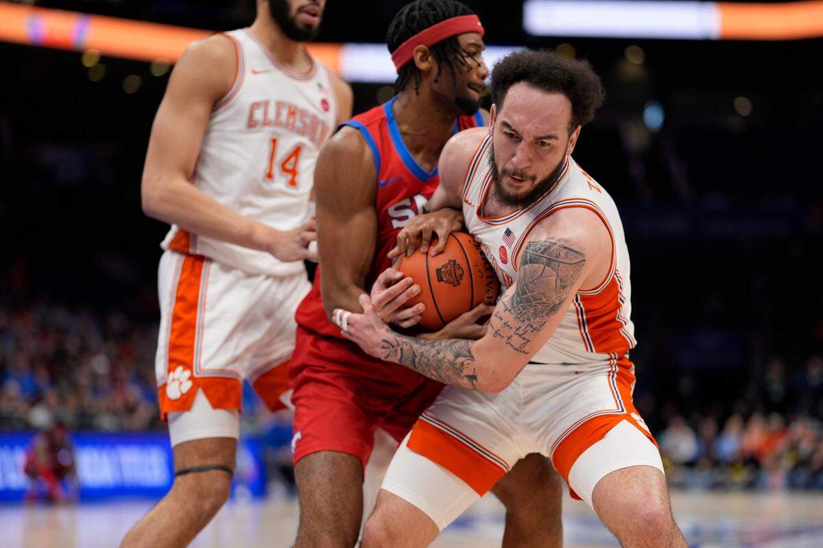 Clemson Tigers guard Jaeden Zackery (11) and Southern Methodist Mustangs forward Yohan Traore (21) fight for the rebound during the first half at Spectrum Center.