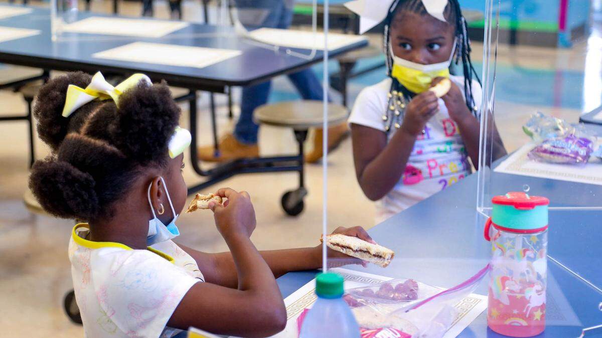 Pre-K students Kahli Pinckney and Madison Smith eat lunch on Wednesday, Aug. 18, 2021, the first day of school at A.C. Moore Elementary School.
