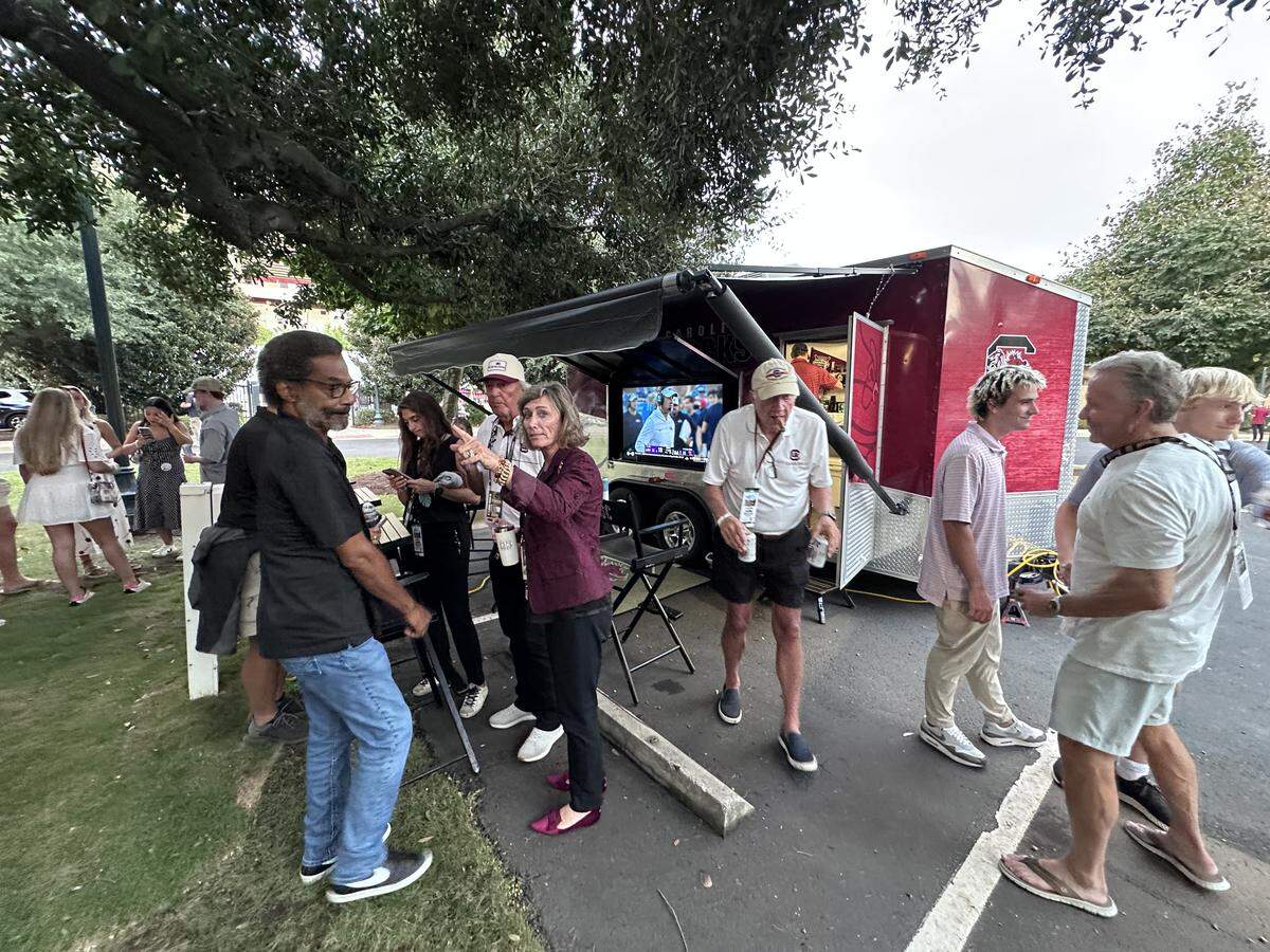 Lisa Rice (garnet blazer) hangs out at the family tailgate before a September USC game.