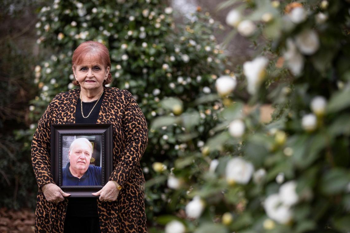 Karen Lovette posses for a portrait holding a photograph of her husband Al Lovette in Camden, South Carolina on Tuesday, March 2, 2021. To protect her and others from the coronavirus, Karen was not able to be near her husband after he died.