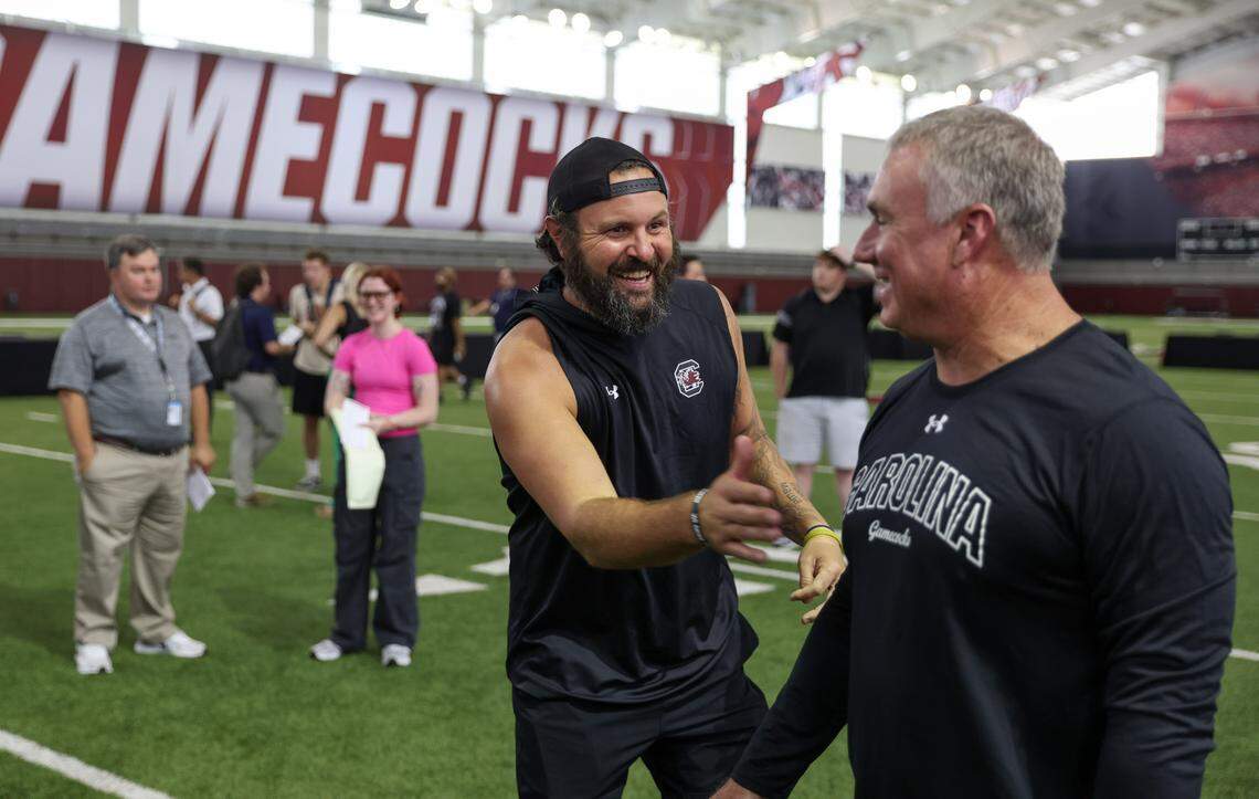 Former South Carolina quarterback Stephen Garcia laughs with run game coordinator Shawn Elliott during media day in Columbia on Thursday, August 1, 2024.