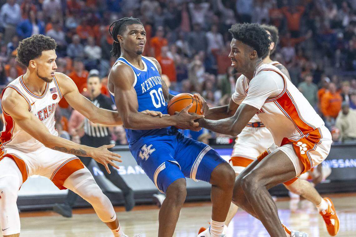 Kentucky Wildcats guard Otega Oweh (00) drives the ball as Clemson Tigers guard Chase Hunter (1) and Clemson Tigers forward Chauncey Wiggins (7) defend during a game at Littlejohn Coliseum in Clemson, S.C., on Tuesday, Dec. 3, 2024.