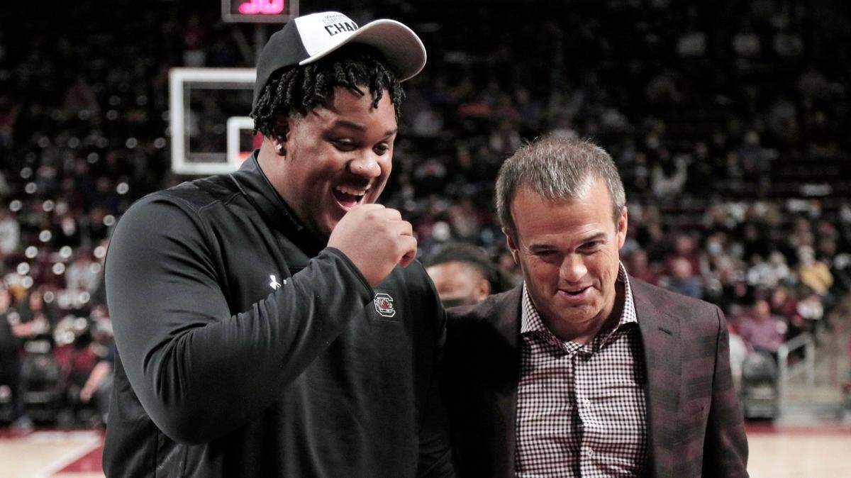 South Carolina freshman football player D’Andre Martin speaks with South Carolina coach Shane Beamer at a basketball game last month. Martin is among the team’s midyear enrollees.