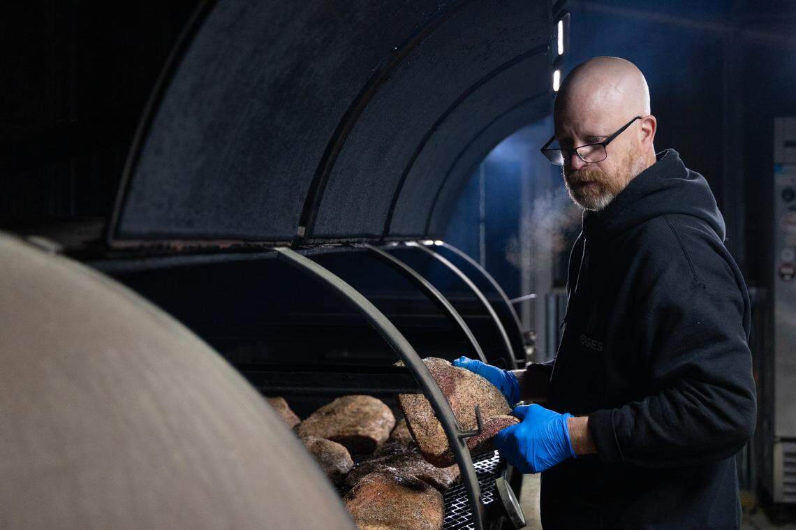 Robbie Robinson, owner of City Limits Barbeque in West Columbia, organizes over a dozen briskets before dawn on Friday, March 28, 2025. Some of the briskets are larger than normal, and organizing their proximity to heat can save preparation time.