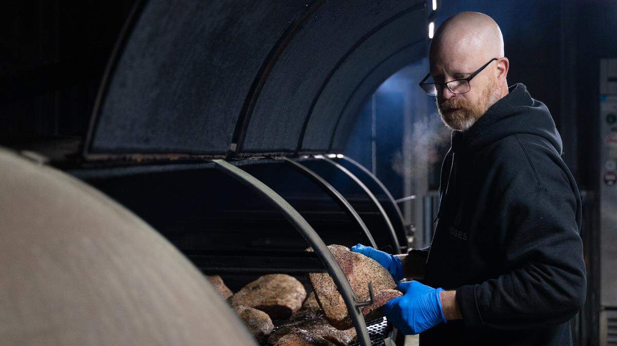 Robbie Robinson, owner of City Limits Barbeque in West Columbia, organizes over a dozen briskets before dawn on Friday, March 28, 2025. Some of the briskets are larger than normal, and organizing their proximity to heat can save preparation time.