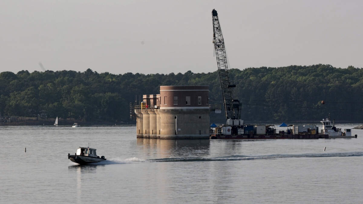 A barge and crane are stationed near the intake towers as part of a construction project on the intake towers on Lake Murray.