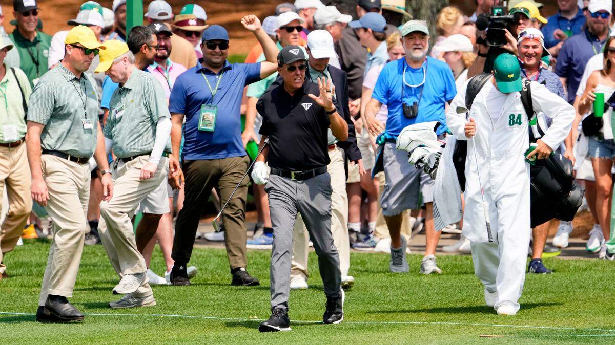 Phil Mickelson walks onto the second fairway after hitting from the second cut during the first round of The Masters golf tournament.