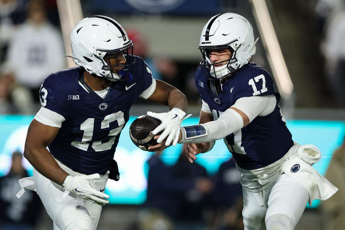 Ethan Grunkemeyer #17 of the Penn State Nittany Lions hands the ball off to Kaytron Allen #13 during the first half against the Nebraska Cornhuskers at West Shore Home Field at Beaver Stadium on November 22, 2025 in State College, Pennsylvania.