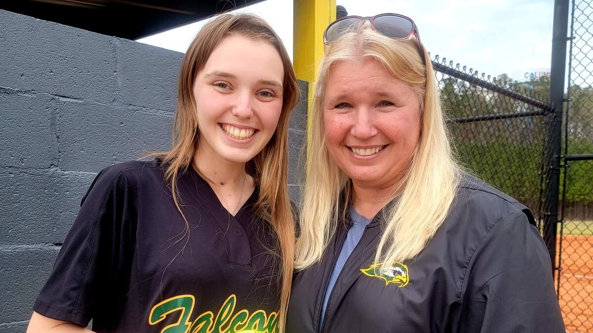 Ben Lippen’s Jessica Kolp, left, and her mother Cheryl pose for a photo after Jessica threw out the first pitch of the Falcons game against Cardinal Newman.