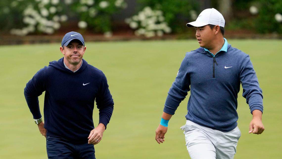 Rory McIlroy and Tom Kim walk to the No. 12 tee during a practice round Monday for The Masters golf tournament at Augusta National Golf Club.