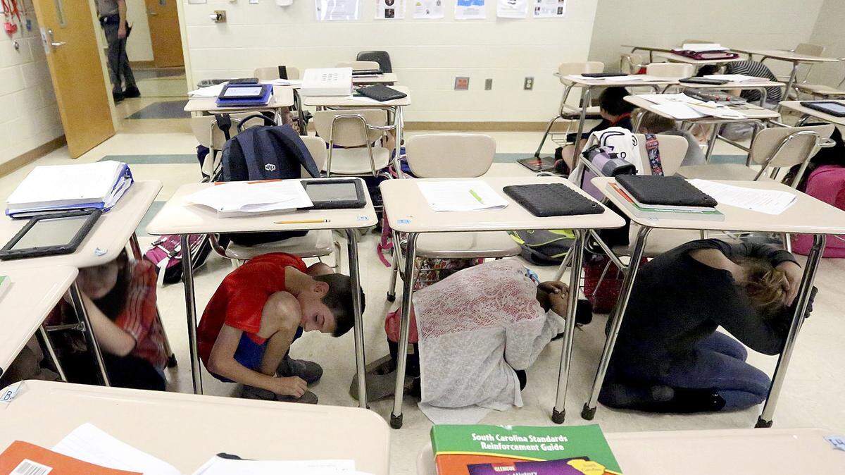Seventh graders huddle beneath their desks during an earthquake drill at Ocean Bay Middle School in 2014 in Carolina Forest, SC.