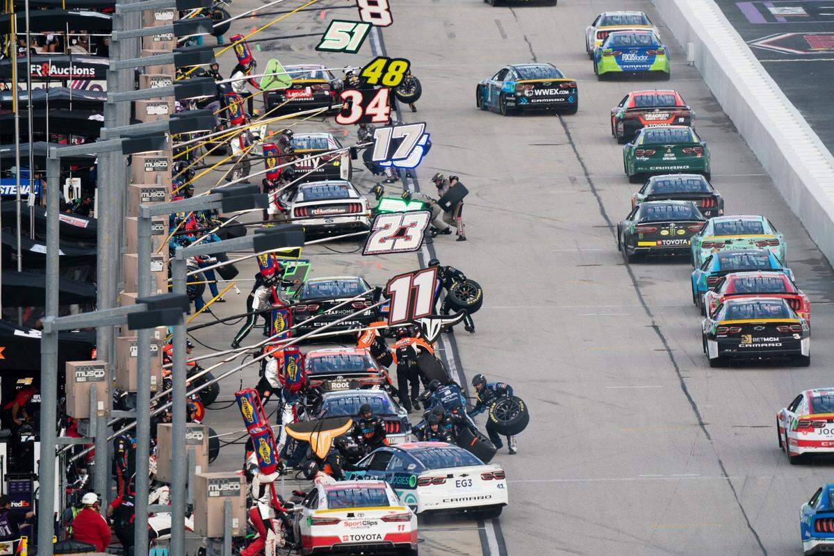 Race teams make pit stops during the NASCAR Southern 500 auto race Sunday, Sept. 4, 2022, in Darlington, S.C. Eric Jones won the race after taking the lead from Kyle Busch when Busch blew a motor with 30 laps remaining in the race. (AP Photo/Sean Rayford)